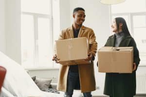 man and women holding moving boxes